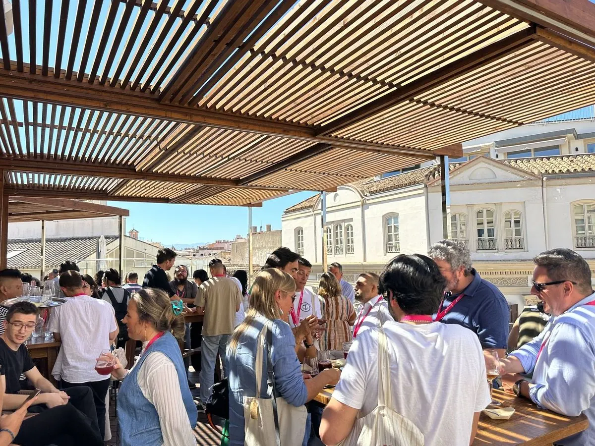 Grupo de invitados de un evento de empresa bajo la pérgola de la terraza