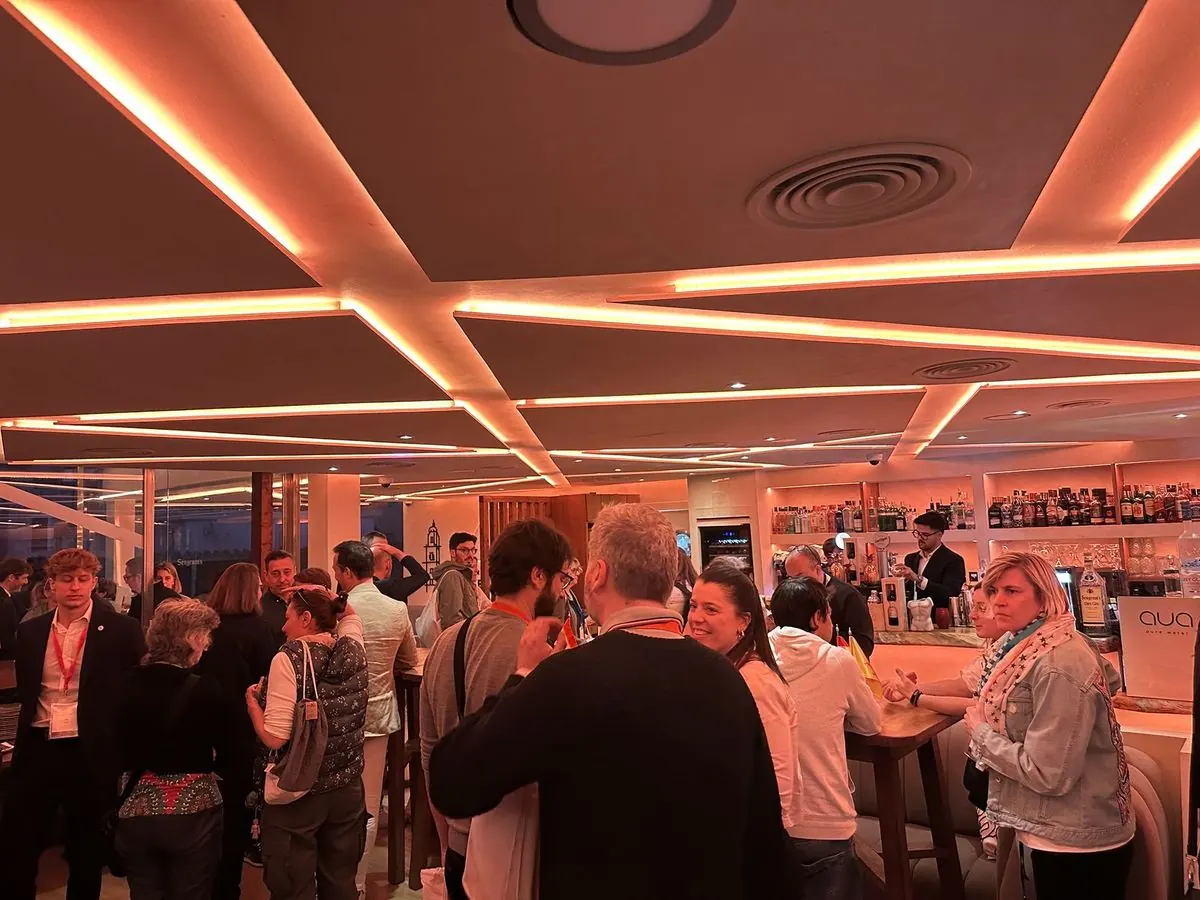 Invitados de pie durante un cóctel de empresa en el salón