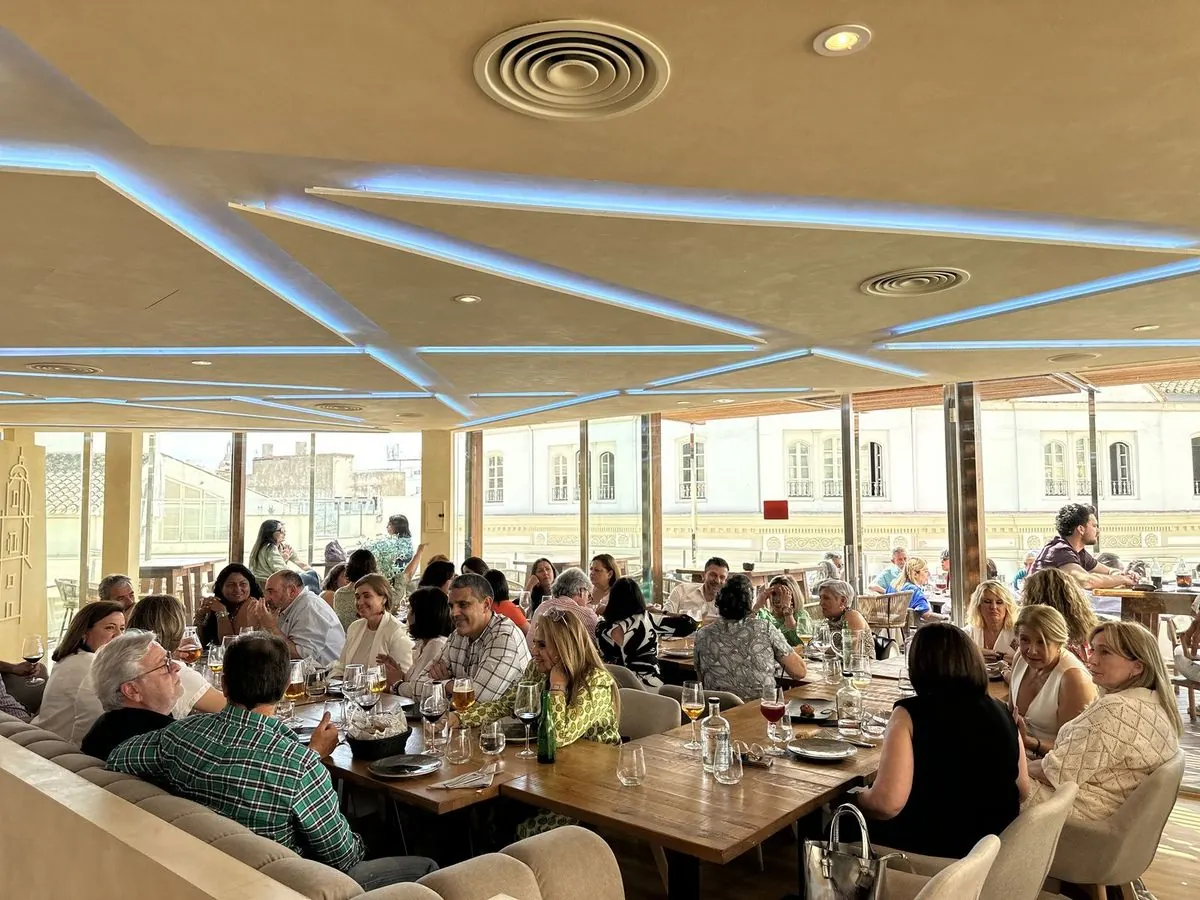 Comida de grupo con el salón lleno y vistas al centro de Málaga